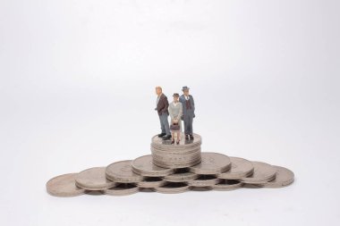 Mini model figürleri madeni para yığınları üzerinde karar veriyor