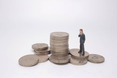 Mini model figürleri madeni paralar üzerinde karar veriyor..