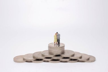 Bir Mini insanlar: madeni paraların üzerinde duran bir çift