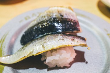 Lezzetli ızgara uskumru suşisi beyaz tabağa güzelce yerleştirilmiş.