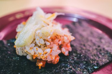 Renkli malzemelerle süslenmiş suşi pilavı.  