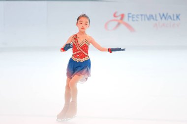 Zarif genç kız buzda kayıyor, göz kamaştırıcı bir figür sergiliyor.