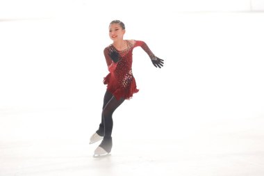 Mavi elbiseli yetenekli artistik patinajcı zarif bir şekilde karmaşık bir duruş sergiliyor.