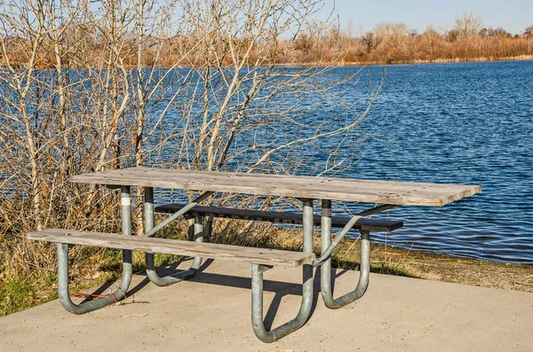 Picknickbord vid en sjö — Stockfoto