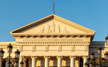 Alacakaranlığın altın ışığı ve Makedonya 'nın kuzeyindeki Üsküp şehir merkezindeki Arkeoloji Müzesi cephesi