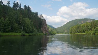 Yüksek kayaları ve dağ ormanları olan bir nehri olan süper manzara.