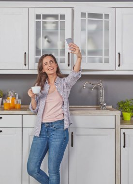 Bir kahve zevk ve bir selfie yapma neşeli kadın