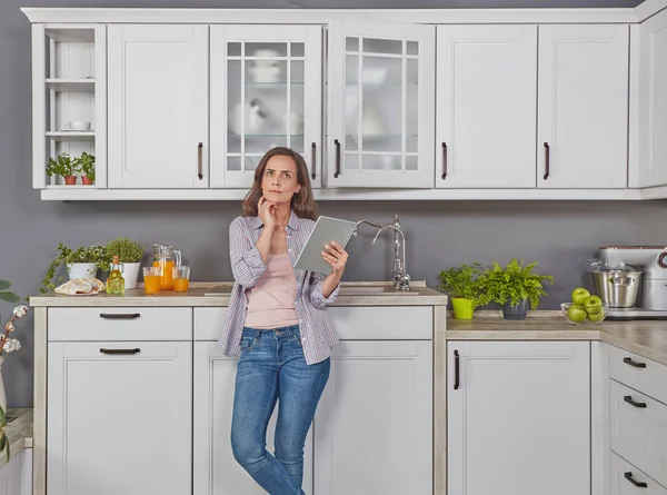 Kadın dijital tablet ile mutfakta