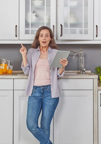 Woman in kitchen with digital tablet