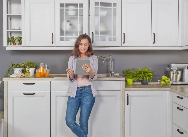 Kadın dijital tablet ile mutfakta