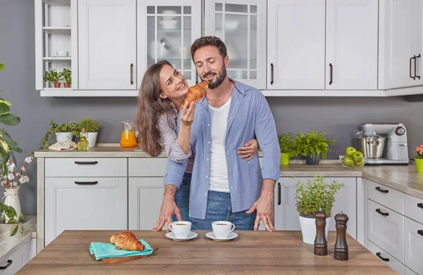 Young couple in love in the kitchen eating breakfast