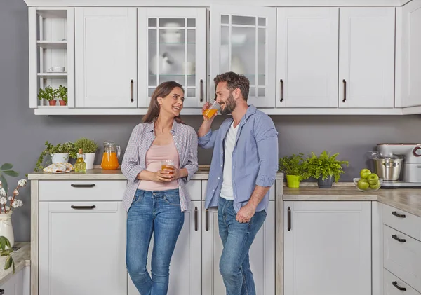 Young couple in love in the kitchen enjoying a glass of juice