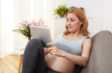 Hamile kadın bir dijital tablet ile rahatlatıcı