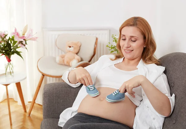 Zwangere Vrouw Houden Schoenen Van Jongen — Stockfoto