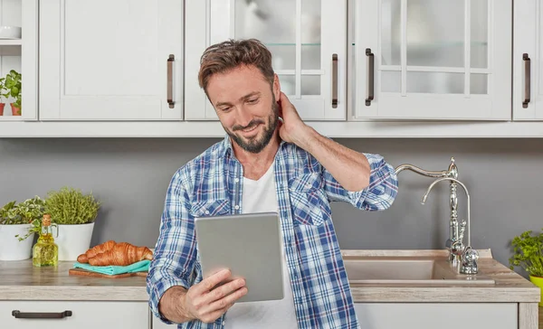 Man in kitchen with digital tablet