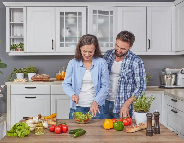 Happily married couple cooking together in the kitchen