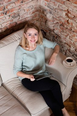 Kanepede bir dijital tablet ile rahatlatıcı