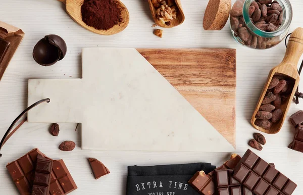 空的切菜板周围有巧克力和甜的食材 — 图库照片