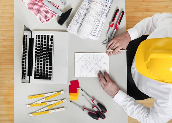 Man working on construction papers at desk