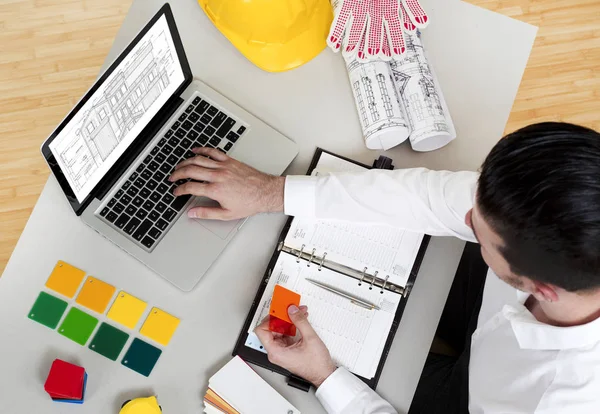 Man working on construction papers at desk