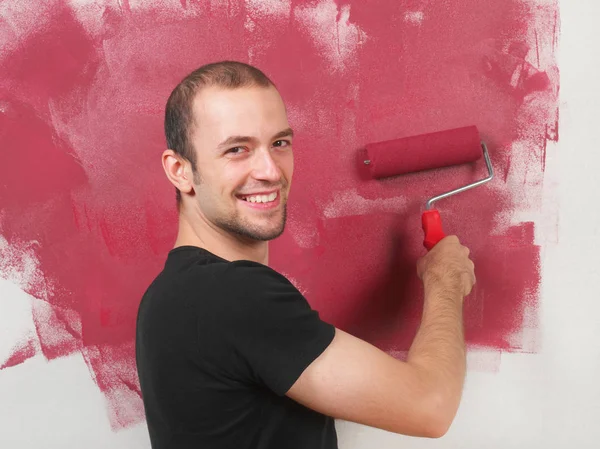 Cheerful man painting the wall