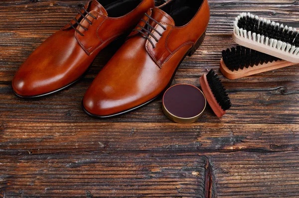 Men leather shoes and care products on wood