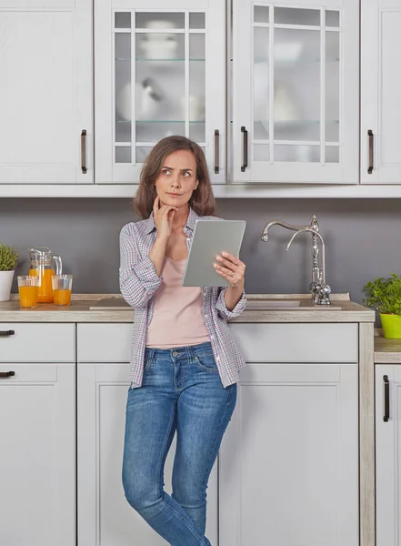 Young woman with digital tablet in the kitchen