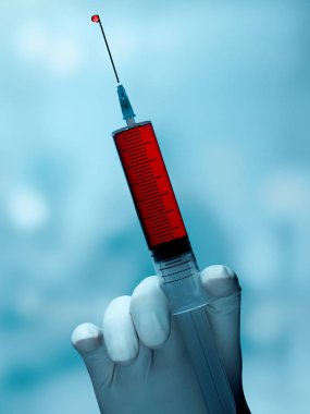 Elinde kanla bir şırınga tutuyor.