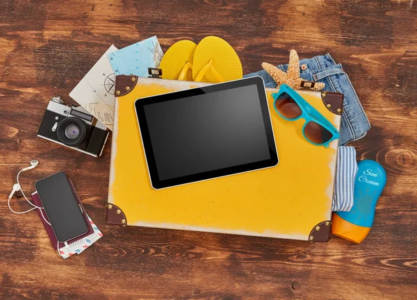 Цифровой планшет, чемодан, одежда и личные принадлежности — стоковое фото