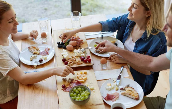 Vänner som har god tid på matbordet — Stockfoto