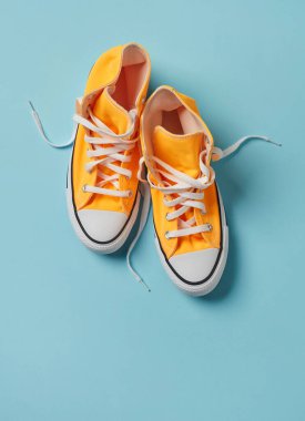 Mavi arkaplanda sarı tuval ayakkabılar