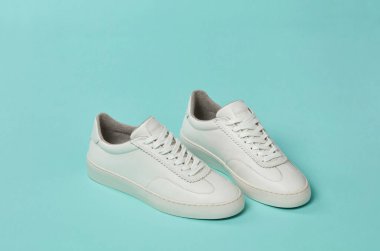 Yeşil arka planda beyaz günlük ayakkabılar