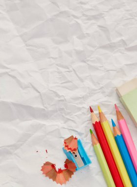 Boş kağıt üzerinde kalemler ve keskinleştiriciler