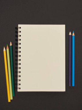 Kağıt defter ve kalemler tahtada.