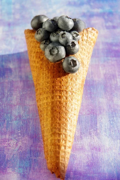 waffle cone with ice cream and blueberries