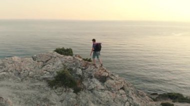 Uzun yürüyüşe çıkan kimse denize karşı sırt çantası ile