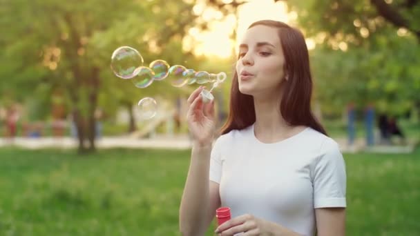 Молодая женщина пускает пузыри — стоковое видео