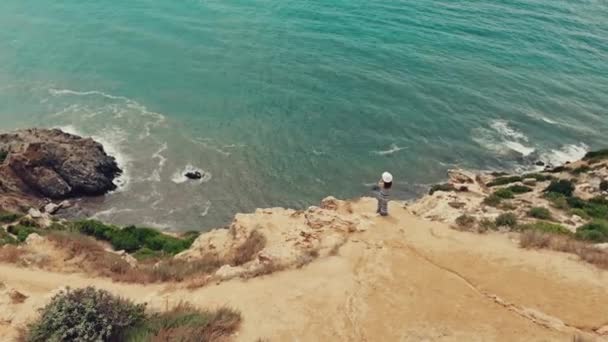 Sola mujer de pie en el acantilado viendo el paisaje marino — Vídeo de stock