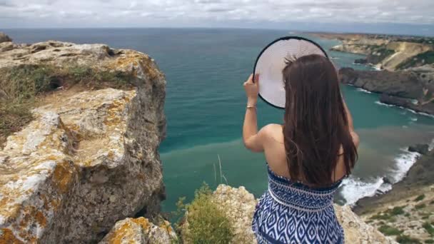 Mujer sentada en la roca y mirando el paisaje marino — Vídeo de stock