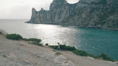 Okyanus ve kayalar karşı yürüyen havadan görünümü kadın