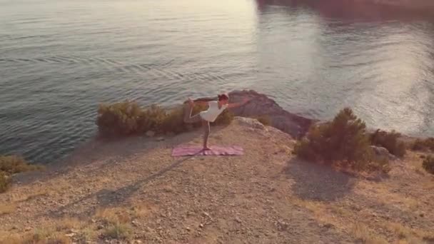 Vrouw doet yoga bij zonsondergang — Stockvideo