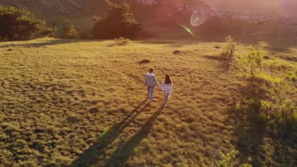 Homem e mulher caminhando ao pôr do sol — Vídeo de Stock