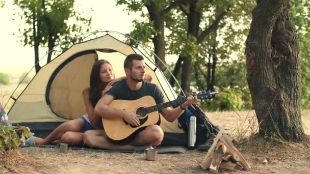 Jong koppel spelen op gitaar in het bos — Stockvideo