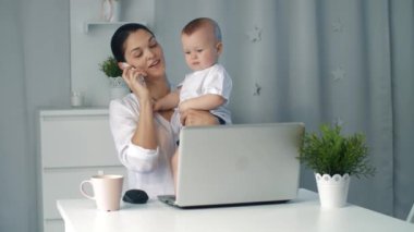 Ev ofisinde çalışırken holding bebek genç anne