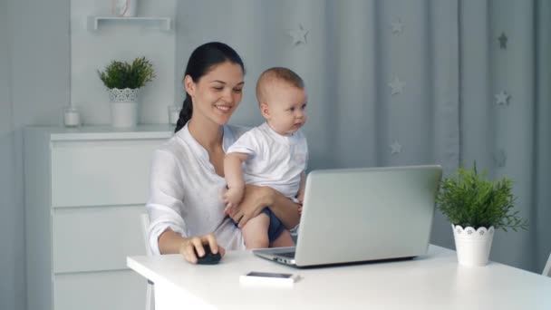 Kobieta kobieta interesu matki z dzieckiem, pracy przy komputerze — Wideo stockowe