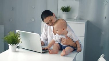 Genç Anne evde laptop ile çalışma