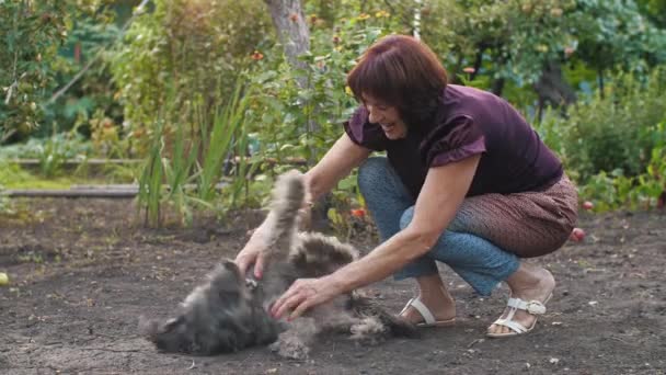 成熟的女人和她的狗玩耍 — 图库视频影像