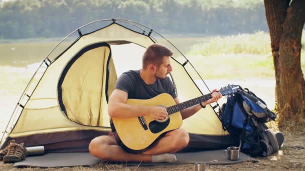 Путешественник играет на гитаре на природе — стоковое видео