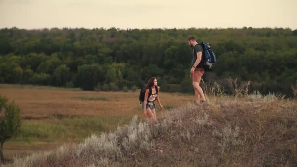 Een man helpt een vrouw te klimmen — Stockvideo