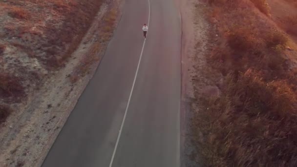 Женщина бегает по проселочной дороге — стоковое видео